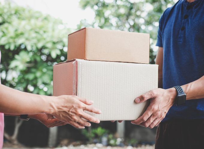 A delivery person handing off a delivery to someone.