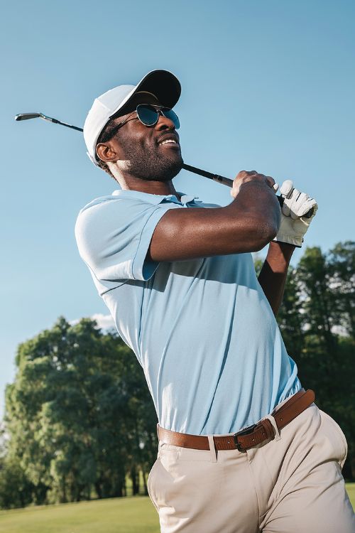 A man in a polo shirt playing golf.